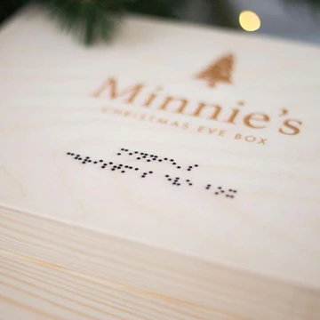 A wooden box which says Christmas Eve Box in Braille